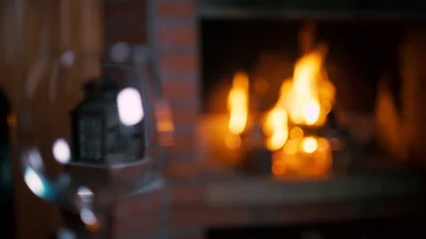 Camera move from a bottle of wine and a glass to a fireplace with flaming fire. Vidéo 138600255