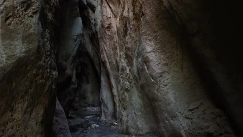 Camera move at the narrow canyon of a mountain cave, illuminated by the sun Stock Footage 158297026