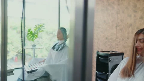 The camera move through the mirror. The footage saw a beautician dyeing a fem Stock Footage 153792844