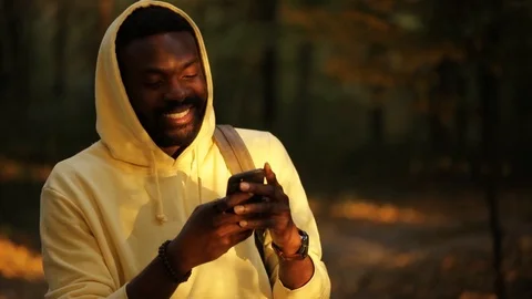 Camera moved around african american young attractive man stand use smartphone Stock Footage 100910290