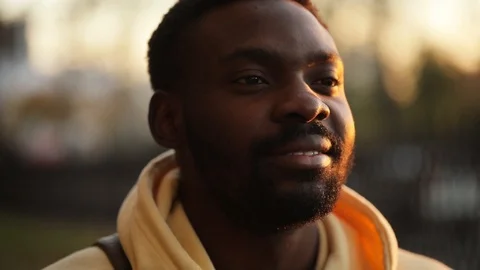 Camera moved around handsome african american man in sun beams stand smile happy Stock Footage 100918673