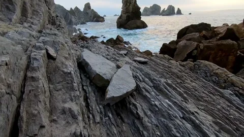 Camera movement across layered coastal rock formations revealing dramatic s.. Stock Footage 343227477