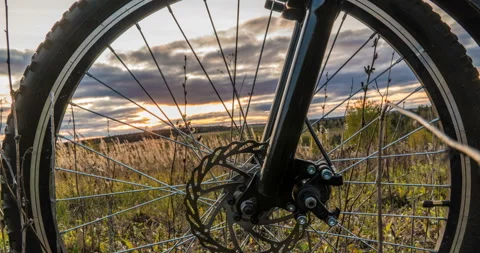 Camera movement along the bicycle against the setting sun, beautiful landscape Stock Footage 118091535