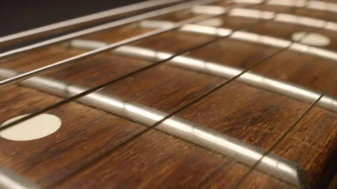 Camera movement along electric guitar fretboard, close-up of frets and strings Stock Footage 332797639