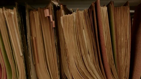 Camera movement along a file shelf. The files are old. Stock-Footage 95427118