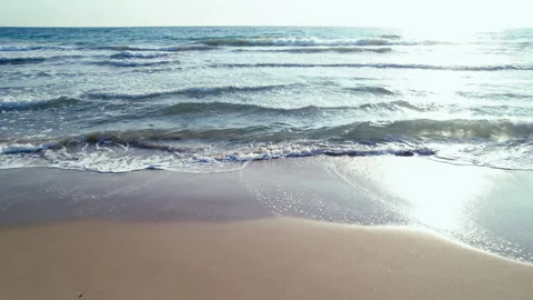 Camera movement along the sandy beach, small calm waves, horizon line Stock Footage 305233467