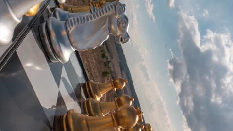 Camera movement between chess pieces on a chessboard against the blue sky and Stock Footage 241749761