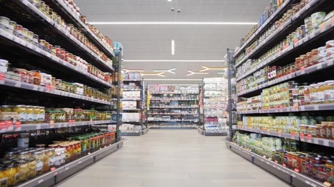 Camera movement between large rows of crowded foodstuffs in a supermarket Stock Footage 247465326