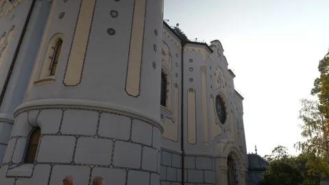 Camera movement revealing sun from behind blue church in Bratislava Stock Footage 120532369