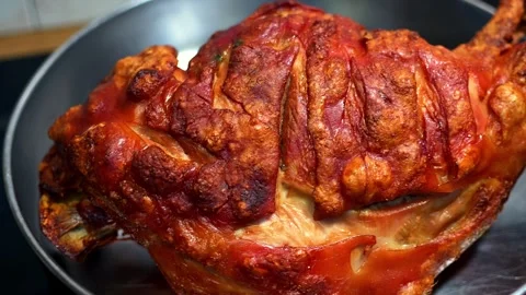 Camera movement on top of a roasted pork leg inside a pan at a home kitchen. Stock Footage 296425243