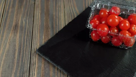 Camera moves up above plastic container with cherry tomatoes Stock Footage 129745083