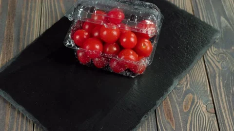 Camera moves up above plastic container with cherry tomatoes Stock Footage 130515876