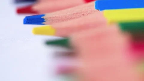 Camera moves above rows of colored pencils on white background. Endless coloring Stock Footage 139357450