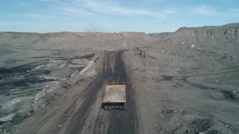 Camera moves after big dump truck loaded to the top with coal. Aerial view Stock Footage 203917332