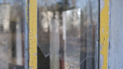 The camera moves along the broken window of an abandoned building. Stock Footage 127248149