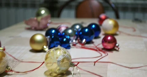 The camera moves along the Christmas tree toys laid out on the table. Stock-Footage 226505963