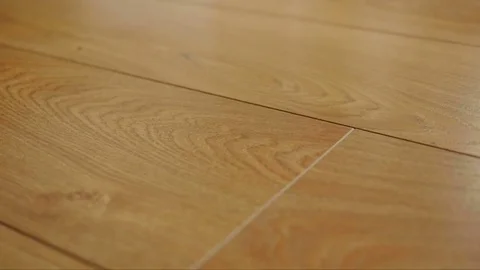 The camera moves along the floor, covered with laminated parquet with a brown Stock Footage 85400391