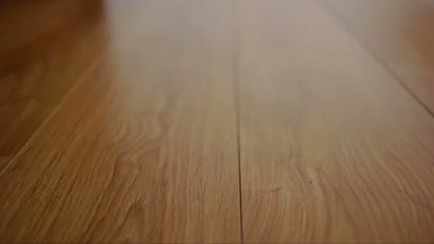 The camera moves along the floor, covered with laminated parquet with a brown Stock Footage 85400494