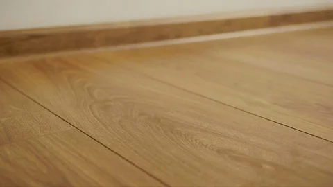 The camera moves along the floor, covered with laminated parquet with a brown Stock Footage 85400722