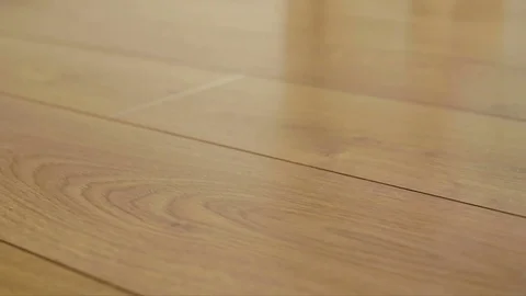 The camera moves along the floor, covered with laminated parquet with a brown Stock Footage 85400789