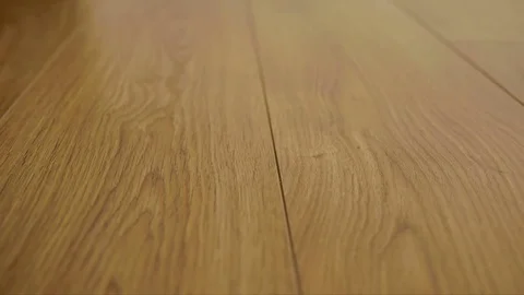 The camera moves along the floor, covered with laminated parquet with a brown Stock Footage 85400899