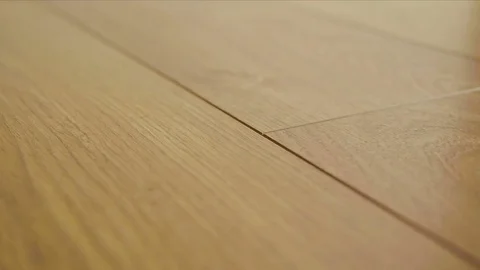 The camera moves along the floor, covered with laminated parquet with a brown Stock Footage 85401064