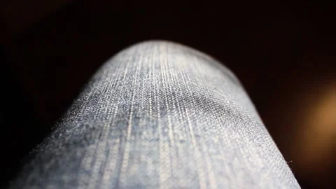 The camera moves along the front of the thigh in jeans, closeup Stock Footage 135732595
