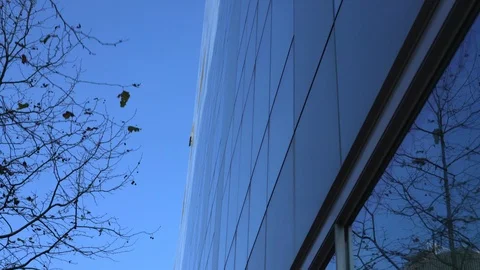 The camera moves along the glass facade of a typical office building Stock Footage 125640610