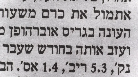 Camera moves along a newspaper sheet in Hebrew, macro view, slider moving 库存影片 126758716