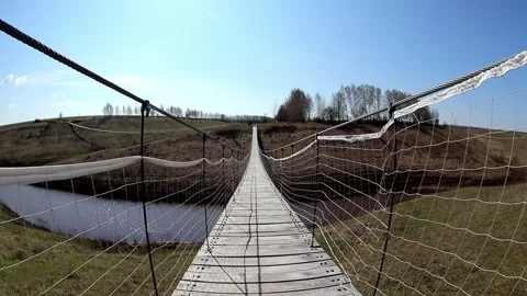 Camera moves along the rope bridge across the river in the national park Video stock 169522325