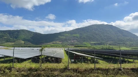 Camera moves along rows of solar panels installed in open fields, showing Stock Footage 327837519