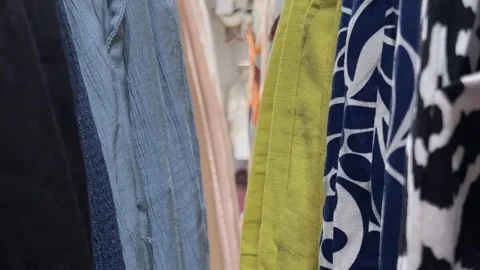 Camera moves along shelf with clothes on hangers in clothing store Stock Footage 312513145