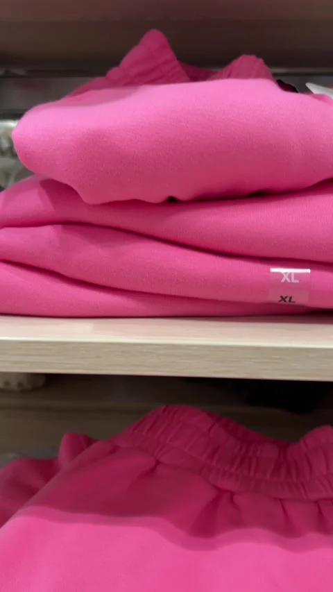 Camera moves along shelf with new pink cotton pants with XL mark Stock Footage 308539373