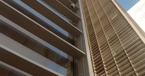 Camera moves along the wall of an office building in the evening at sunset Stock Footage 156512222