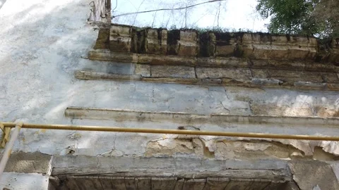 The camera moves along the wall of an old, ruined house, the camera goes up. Vídeos de archivo 168419820