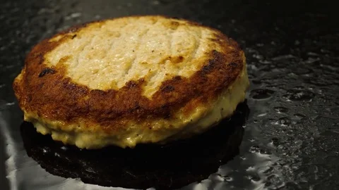 Camera moves around of cooking juicy meat burger, Chef flips over grilling meat Stock Footage 76897853