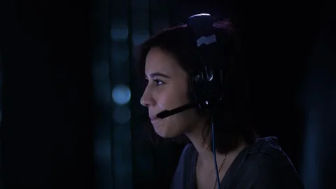 Camera moves around cute laughing girl talking over headset Stock Footage 101252519