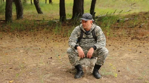 The camera moves around a handsome young caucasian traveler in camouflage clothe Video stock 113935400