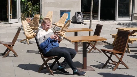 Camera moves around handsome young man as he uses his phone. Portrait. Blurred Stock-Footage 118762743