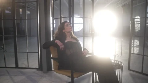 The camera moves around the model sitting relaxed in a chair Vidéo 261559251