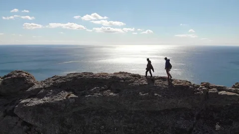 Camera moves around people watching sea from high rock top Video stock 103835963