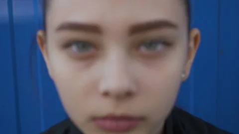 The camera moves away from the face of a cute teen with beautiful slanted eyes Stock Footage 114330979