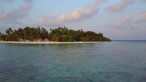 The camera moves away from round tropical atoll island resort hotel with white Stock Footage 77550331