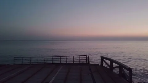 Camera moves away from a statue on a small wooden pier in the sea. Stock Footage 70531376