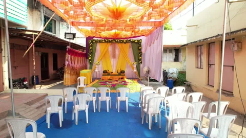 The camera moves back from a courtyard ceremony setup with orange overhead 스톡 동영상 347567701