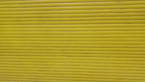 The camera moves backward from a bright yellow metal roller shutter door. Stock Footage 338405188