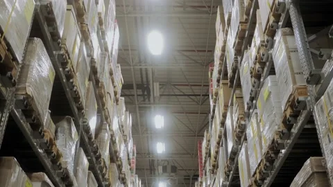 The camera moves between rows in a warehouse filled with boxes. Stock Footage 222602861