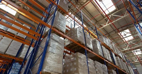Camera moves between shelves with palettes and boxes in a big modern logistic Stock Footage 109795477