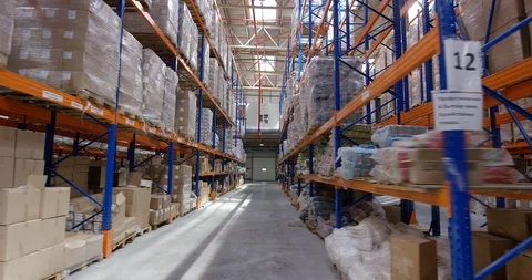 Camera moves between shelves with palettes and boxes in a big modern logistic Stock Footage 109795973