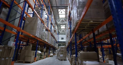 Camera moves between shelves with palettes and boxes in a big modern logistic Stock Footage 109796524